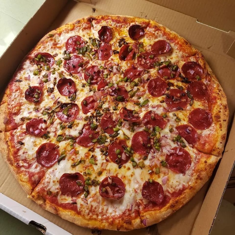 A Brooklyn Pizzeria pepperoni pizza with green peppers and red onions in a cardboard box.